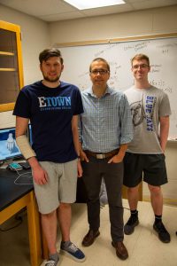 Two Etown students with professor, smiling at camera in Esbenshade lab.