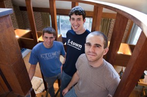 three male students on spiral staircase inside one SDLC house