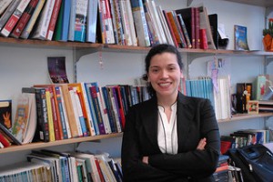 Dr. Oya Dursun-Ozkanca poses in front of her office's bookshelf